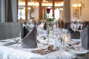 图克斯阿尔本杰威尔耶格尔酒店的一张桌子,上面有白色的桌布,上面有玫瑰花