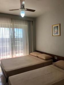 拉古纳Atlântico Sul Renascença Hotel的一间卧室配有两张床和吊扇