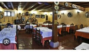GarrayHotel la posada de Numancia的餐厅配有桌椅和白色的桌布