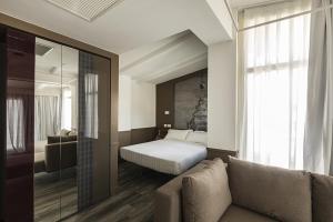 罗马内葛诺酒店的一间卧室配有一张床、一张沙发和一个窗口