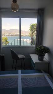 马萨龙港El Faro seacave的客房设有带椅子和书桌的窗户。
