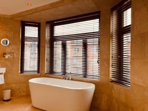 布兰肯贝赫Gatsby Hotel - Adults Only - Small Luxury Hotel - by F-Hotels的带窗户的浴室设有大浴缸