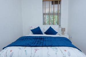伦敦Evergreen Apartments-Flat 4, London的一间卧室配有蓝色和白色的床和蓝色枕头
