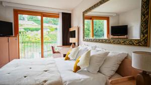尼翁Hôtel Real Nyon by HappyCulture的卧室配有一张带镜子的白色大床