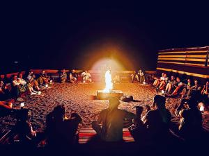 瓦迪拉姆贝都因人时尚露营旅馆的一群人坐在火坑周围