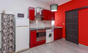 马德里Desing Puerta del Sol 6的厨房配有红色橱柜和白色冰箱