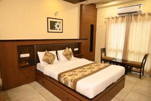 阿杰梅尔阿杰梅尔普拉扎酒店的一间卧室配有一张床、一张桌子和一张四柱床。