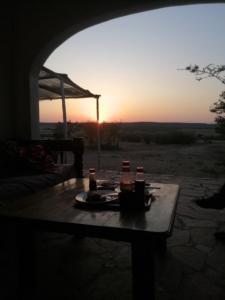 塔勒克Narasha Homestay - Maasai Mara的一张桌子,上面放着一盘食物,还有日落