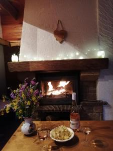 马尼戈Chalet de Manigod的餐桌,餐桌上放着一盘食物,壁炉