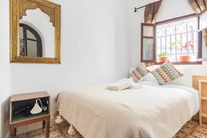 丹吉尔Casa al Captane au Medina Tanger的卧室配有一张壁挂镜子的床