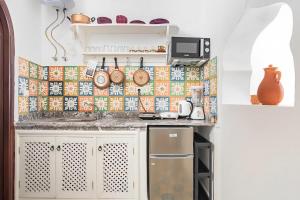 丹吉尔Casa al Captane au Medina Tanger的厨房配有白色橱柜和瓷砖墙。
