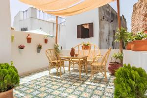 丹吉尔Casa al Captane au Medina Tanger的庭院配有桌椅和植物