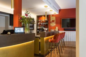 阿莫尔巴赫EMICH´S Hotel的一间酒吧,拥有橙色的墙壁和橙色的凳子