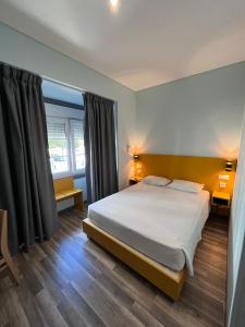 里斯本丰特鲁米诺萨酒店的一间卧室设有一张大床和两个窗户。