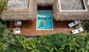 Pwani Mchangani MdogoSensations Eco-Chic Hotel的两人在游泳池游泳的空中景色