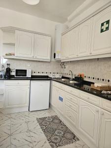 辛特拉Maria Saudade Apartamento的厨房配有白色橱柜和白色冰箱。