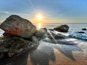 梅坦蓬托Villaggio Mondial Camping的海滩上一群岩石,阳光照耀着