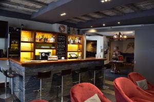 克莱恩 蒙塔纳Hotel Central, Spa & lounge bar的餐厅内的酒吧,带红色椅子