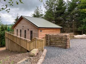 库珀Holly Berry Lodge with Hot Tub的一座带木栅栏的小木结构建筑