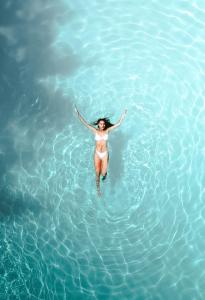 梅拉诺Villa Bavaria的水中游泳的比基尼女人