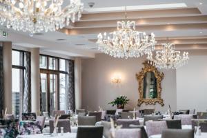 圣安东阿尔贝格珀斯特酒店的用餐室配有吊灯和桌椅