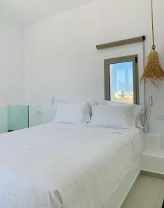 斯基罗斯岛Casa di Amerissa Premium Accommodation的白色的床、白色枕头和窗户