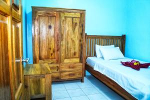 圣吉吉KJ Purple Gate SENGGIGI的一间小卧室,配有一张床和一扇木门