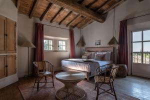 帕拉杜Les Petites Maisons - Hameau des Baux的卧室配有一张床和一张桌子及椅子