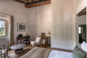 帕拉杜Les Petites Maisons - Hameau des Baux的卧室配有1张床、1张桌子和1把椅子