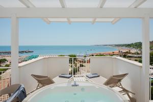 努马纳View Place & Spa的阳台享有海滩美景,配有浴缸。