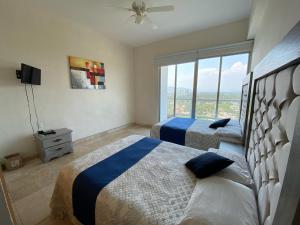 阿卡普尔科Departamento Playa Punta Diamante的一间卧室设有两张床和大窗户