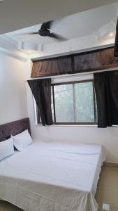 贾巴尔普尔Hotel 100 Meter的窗户客房内的一张白色床