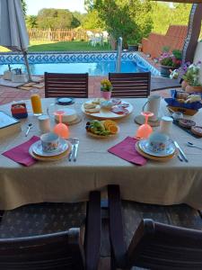 曼塔罗塔Manta Rota Beach, Bed & Breakfast in a villa,privat pool的一张桌子,上面有盘子,放在游泳池边