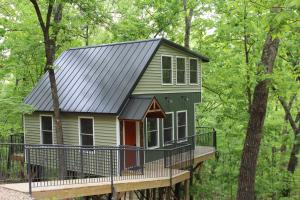 布兰森Secluded Treehouse in the Woods - Tree Hugger Hideaway的树林甲板上的一个小房子