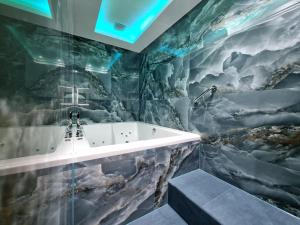 伦敦NOX Kensington Gardens的带浴缸和岩石墙的浴室
