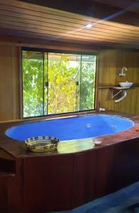 阿尔特杜尚Mizu Spa & Hospedagem的窗户客房内的大蓝色浴缸