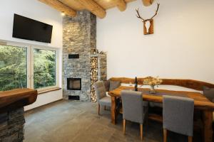 耶塞尼采Alpine Cottage Golica的一间带木桌和壁炉的用餐室