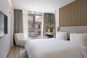 雅典Nur Aparthotel Athens的卧室设有一张白色大床和一扇窗户。