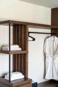 雅典Athens Design Suites的木制架子,带毛巾和浴袍