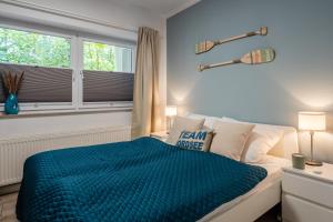 瓦雷尔VIVID - Traumwohnung ruhig und strandnah gelegen的一间卧室配有一张带蓝色棉被的床和窗户。
