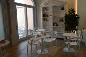 维拉西米乌斯TANIT ROOMS & SPA的客房设有白色的桌椅和窗户。