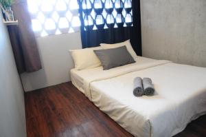 怡保GRAYHAUS INN Ipoh的两张位于房间的床,两双鞋在里面