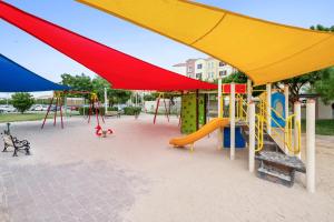 迪拜Luxury studio in Discovery Gardens near metro的公园里一个带五颜六色游戏设备的游乐场