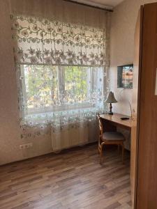陶格夫匹尔斯帕拉迪泽的客房设有书桌和带窗帘的窗户。