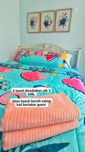 Hmsty D Hutan Kampung Alor Setar (Muslim)的床上铺有色彩缤纷的床单和枕头
