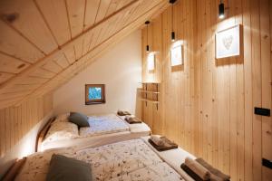 耶塞尼采Alpine Cottage Golica的木墙客房的两张床
