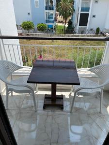 锡德Villa Hania Boutique Hotel - Adults only的阳台上配有一张黑桌子和两把椅子