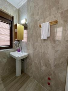 锡德Villa Hania Boutique Hotel - Adults only的一间带水槽和瓷砖墙的浴室