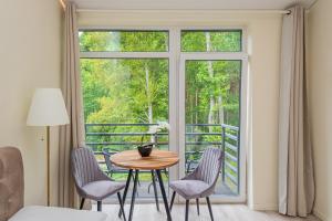帕兰加Seaside apartments 2的客房设有桌椅和窗户。