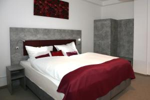 巴特皮尔蒙特Arthotel的卧室配有带红色枕头的大型白色床
